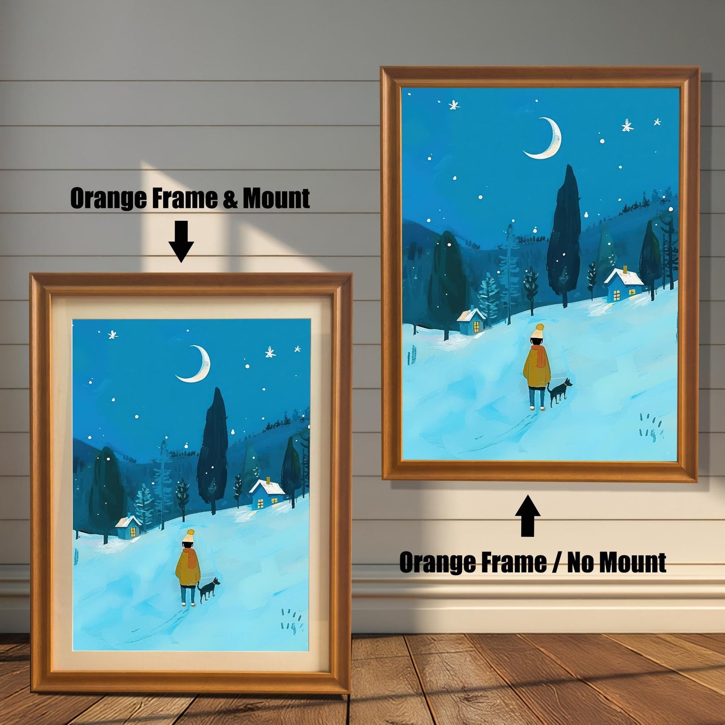 A comparison of two orange-framed wall art prints featuring a person and their dog walking through a snowy, moonlit forest. The print on the left is framed with a white mat, while the one on the right is framed without a mat. The image is shown on a light wood wall.