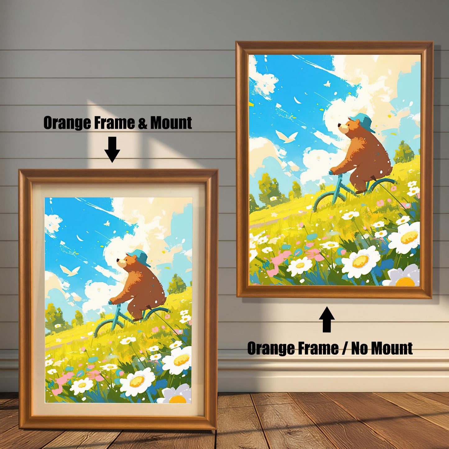 A split image showing the art print in two orange-toned wood frame options. The left print has an orange frame with a white mat, and the right print is in an orange frame without a mat. The cheerful art features a brown bear in a blue hat riding a bicycle through a sunny field of flowers.