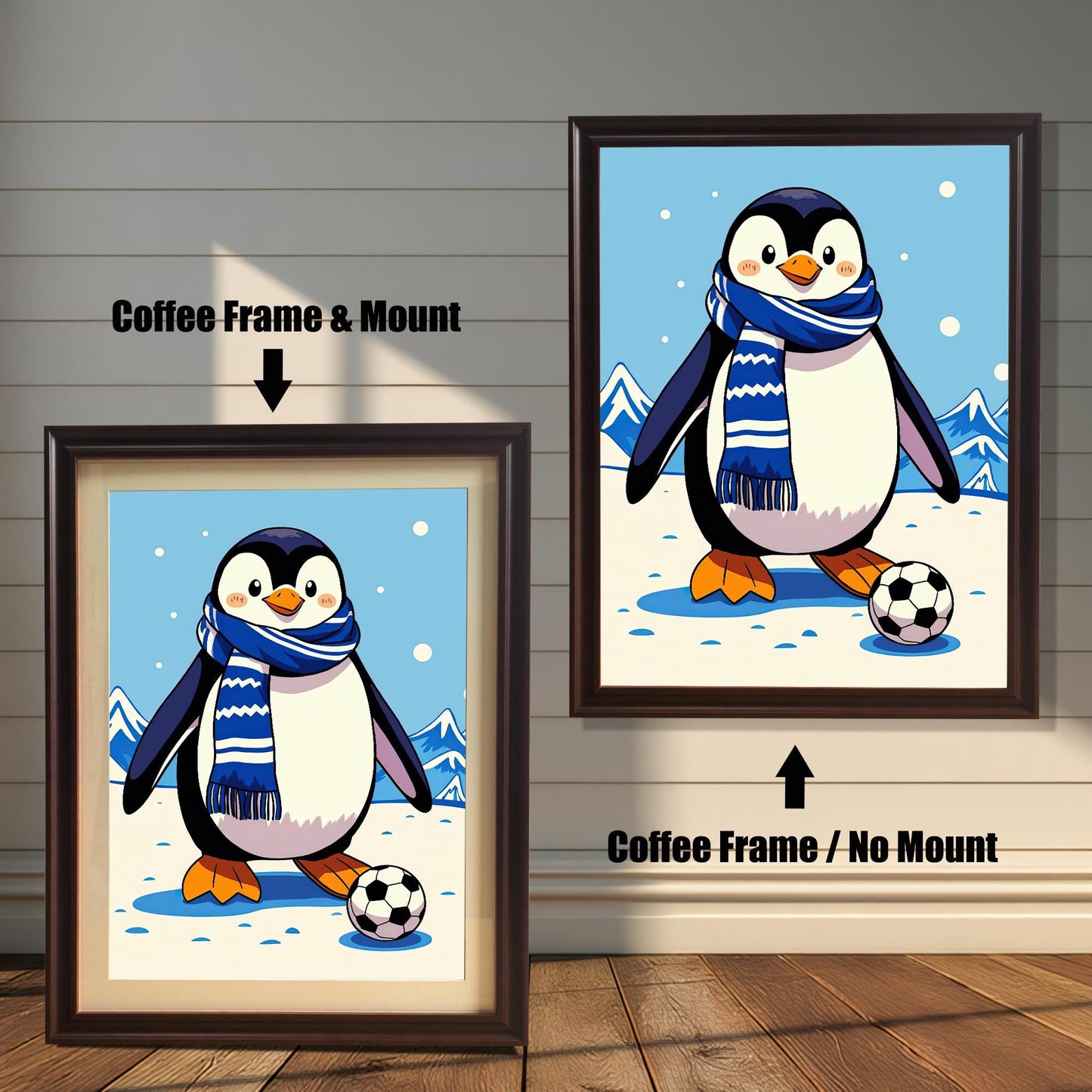 Two framed prints of a penguin playing soccer on a white wood-paneled wall. The one on the left has a coffee-colored frame with a mount. The one on the right has a coffee-colored frame with no mount.