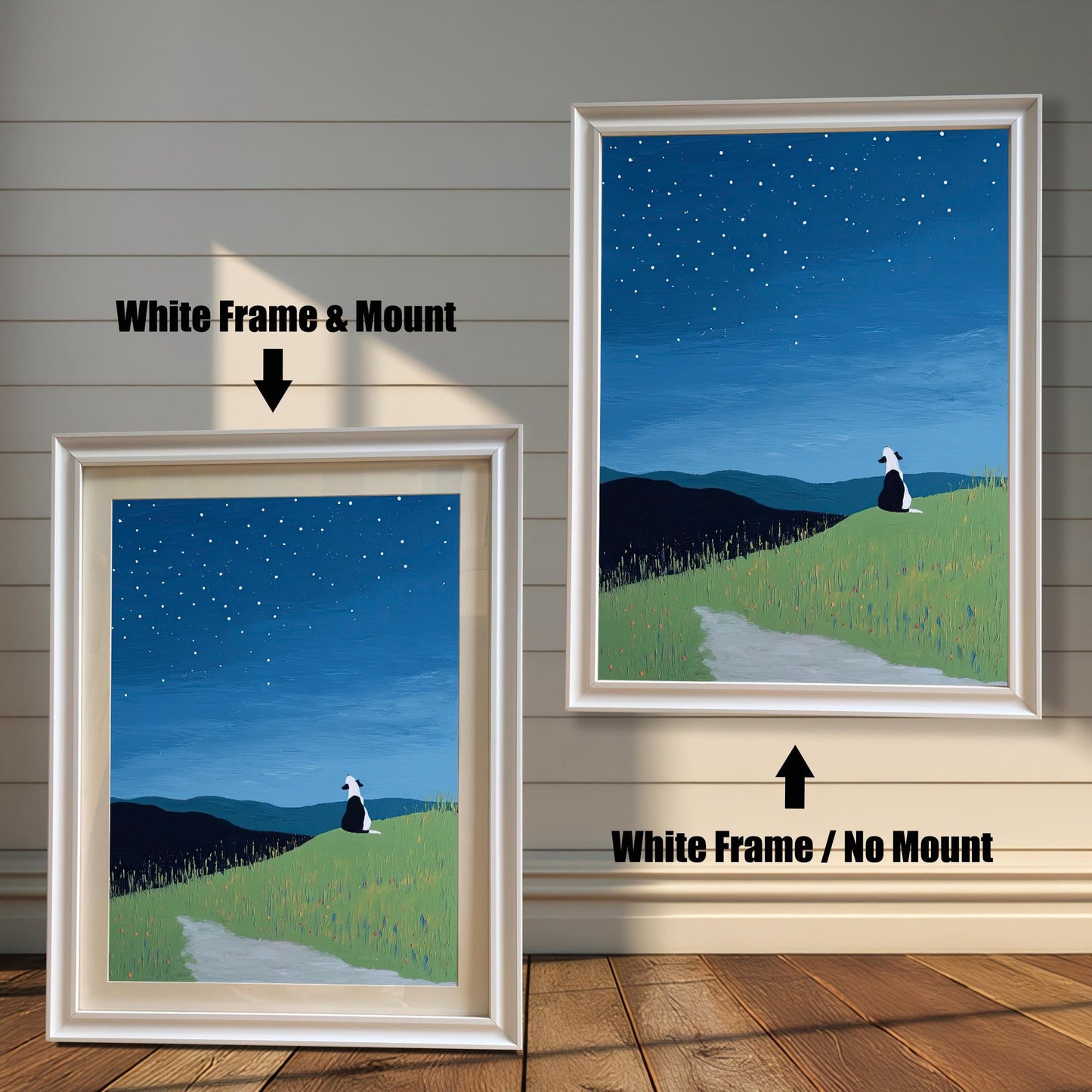 Stylized painting of a black and white dog sitting on a grassy hill, looking up at a dark blue, starry night sky with rolling dark hills in the background. The image shows two framed options: one on the left with a White Frame & Mount (matting), and one on the right with a White Frame / No Mount. Both are displayed against a white wood-paneled wall and a wooden floor.