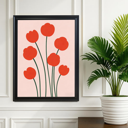 Framed print of the modern red flower illustration hanging on a white paneled wall above a dark wooden surface, next to a large potted palm plant. The frame is Black wood.