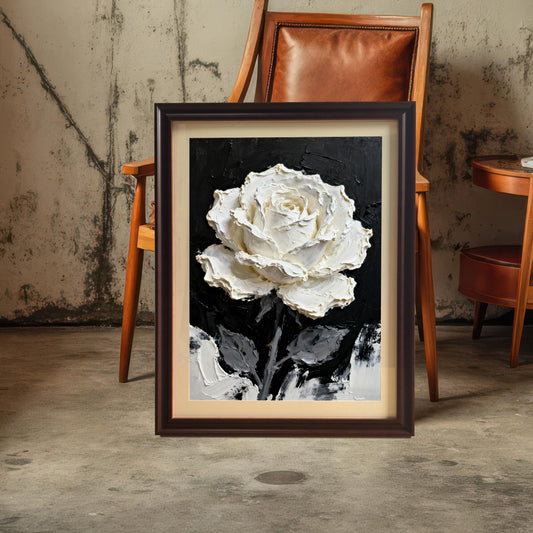 A framed print of the textured white rose painting with a Coffee (dark brown) wood frame and a mount (matting), leaning on a concrete floor in front of a leather armchair.
