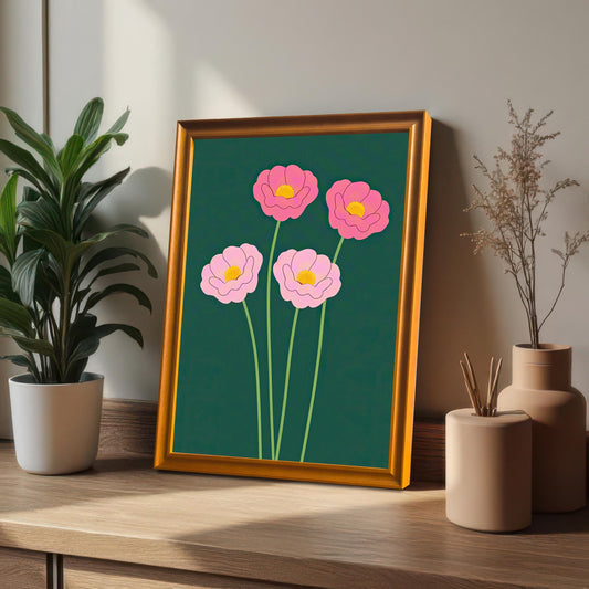 The pink floral art print in an Orange Frame (no mount), propped up on a wooden desk next to a potted houseplant and decorative vases.
