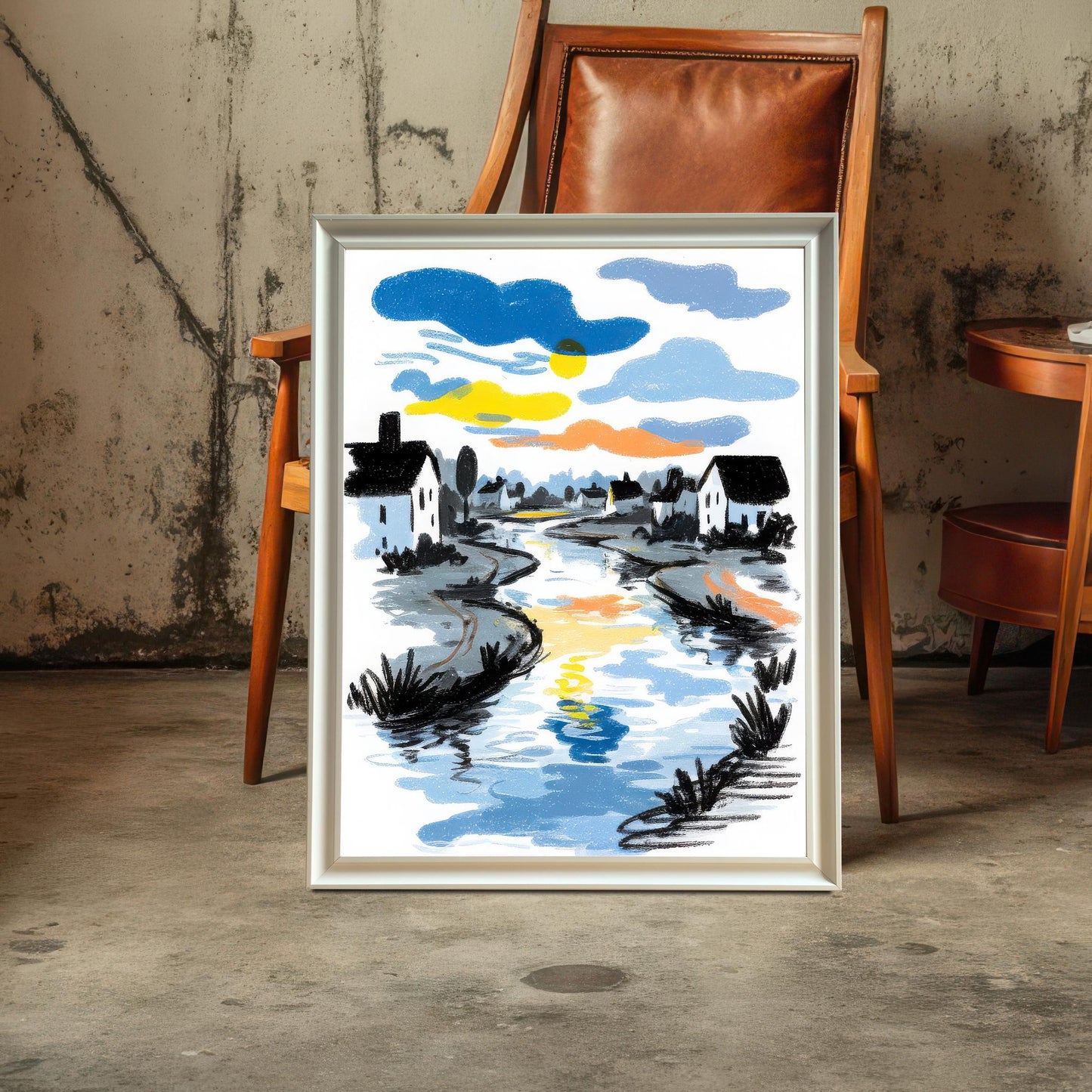 The river art print in a White Frame / No Mount (full bleed print) leaning against a wooden chair with a leather seat, set against a raw concrete wall and floor.