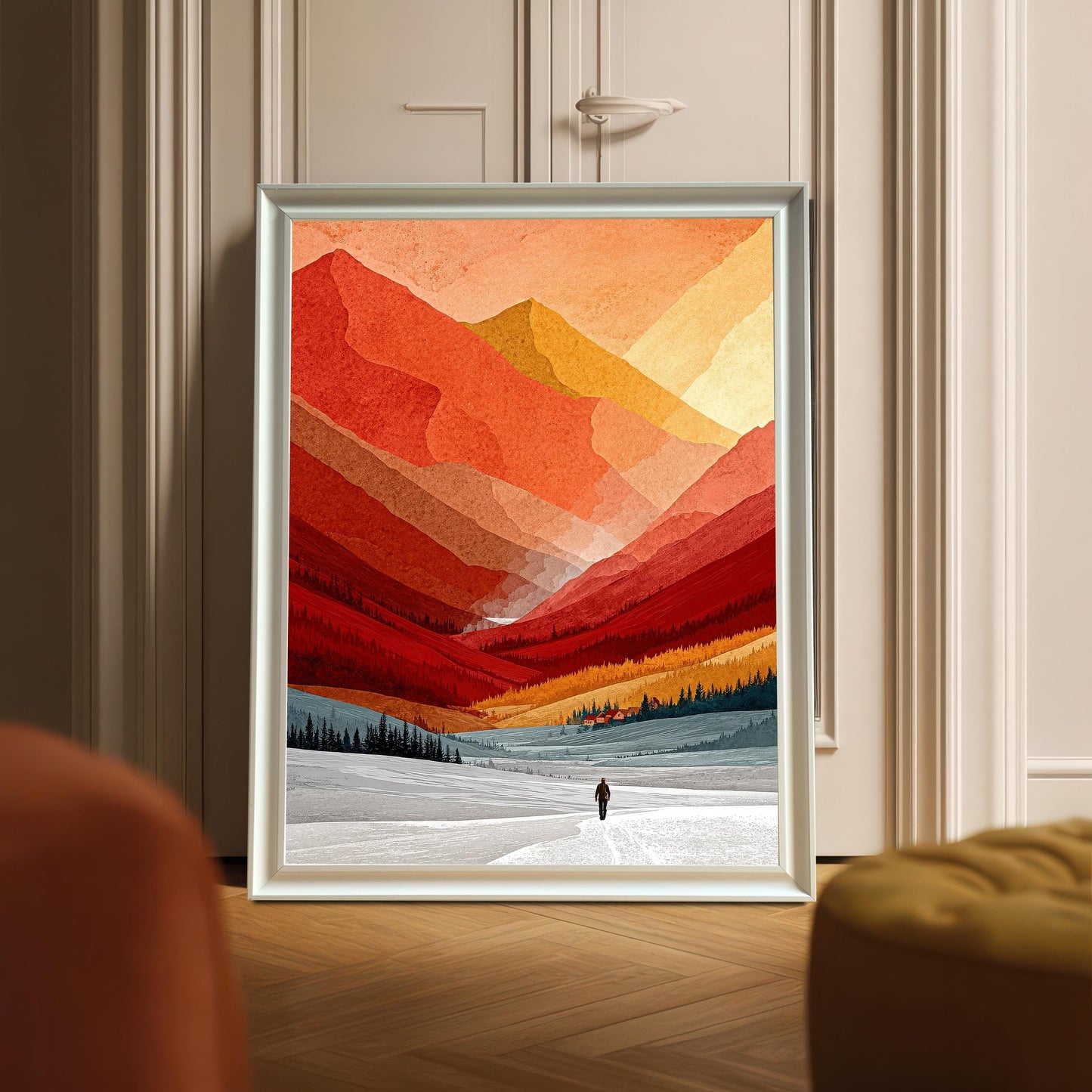 Modern white wood framed mountain art print displayed on a herringbone wood floor, leaning against a neutral paneled door in a bright interior.