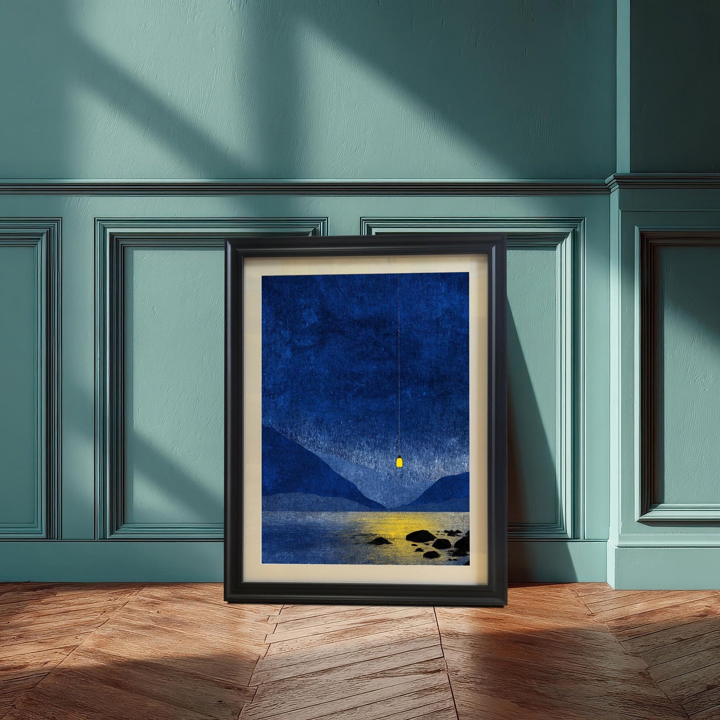 Black wood framed blue lake and glowing lantern print with a cream mount, resting on a herringbone wood floor against a dark teal decorative wall.