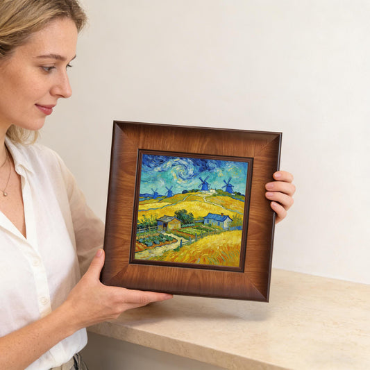 A woman holding the square-framed art print in her hands, showing the size of the piece relative to a person and its suitability as a gift or shelf decor.
