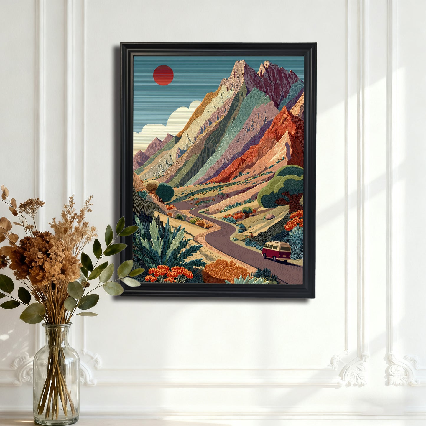 Mountain Road Trip,"Black-framed art print of the vibrant mountain landscape with a winding road, hanging on an ornate white paneled wall.