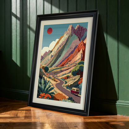 Mountain Road Trip,Black-framed art print of the colorful mountain road trip leaning against a dark green paneled wall. Natural light casts shadows on the wooden floor.