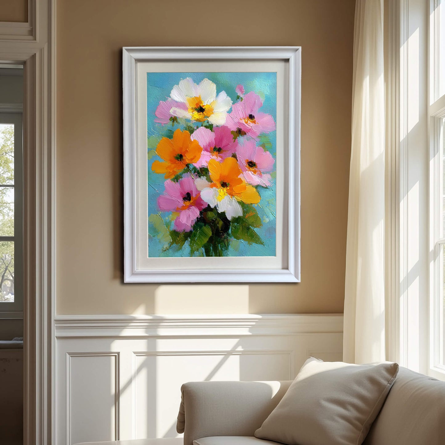 A framed oil painting of a colorful floral bouquet hanging on a beige wall above a cream-colored sofa in a sunlit room with classic white wall molding.