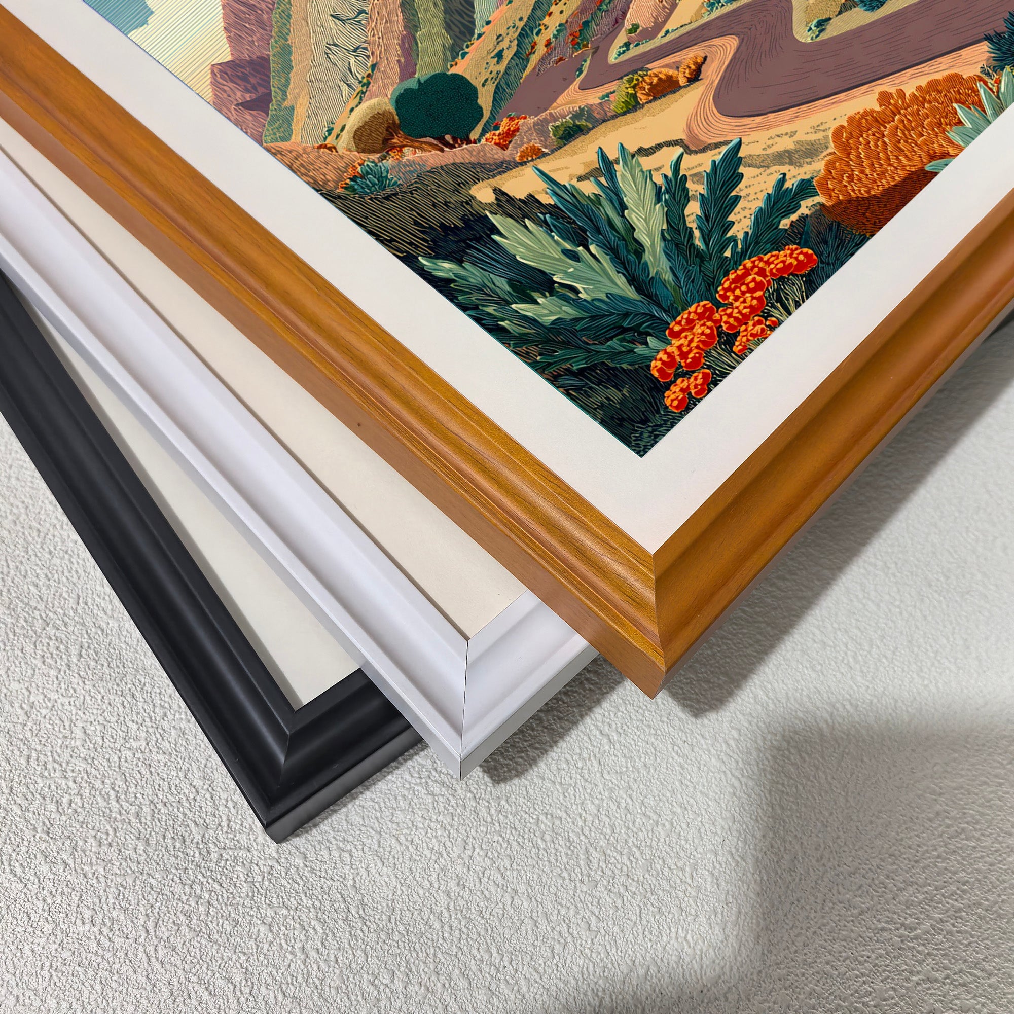 Close-up corner detail of the art print showing three stacked frame options: , white, orange, and black.