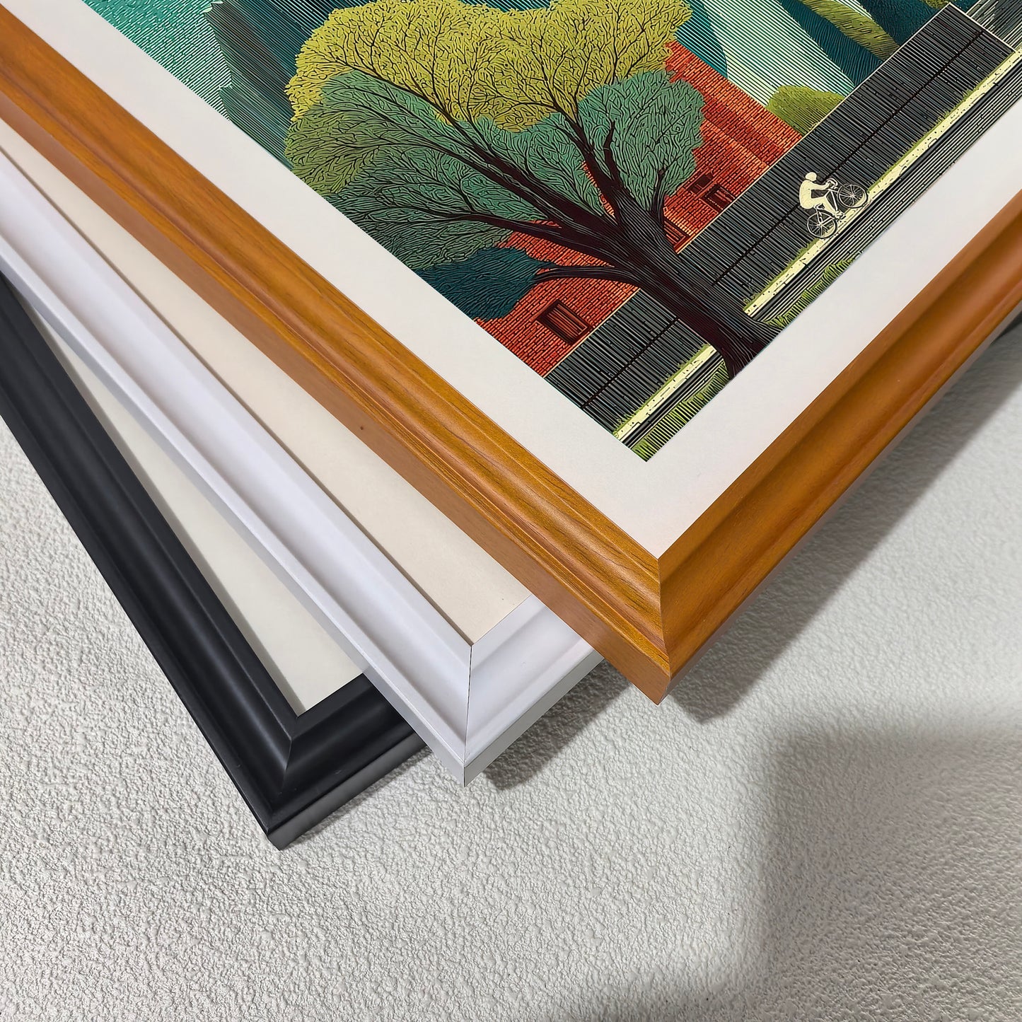 Close-up corner detail of the art print showing three stacked frame options: , white, orange, and black.