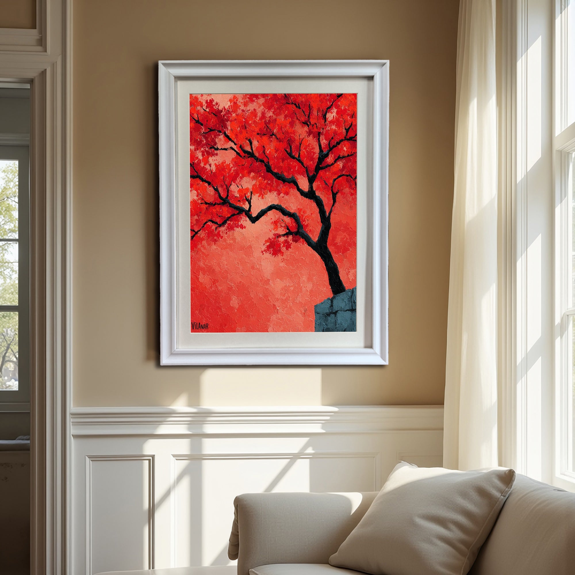A white-framed painting of a vibrant red-orange tree is hanging on a beige wall with white wainscoting, positioned above a cream-colored sofa near a large, curtained window.
