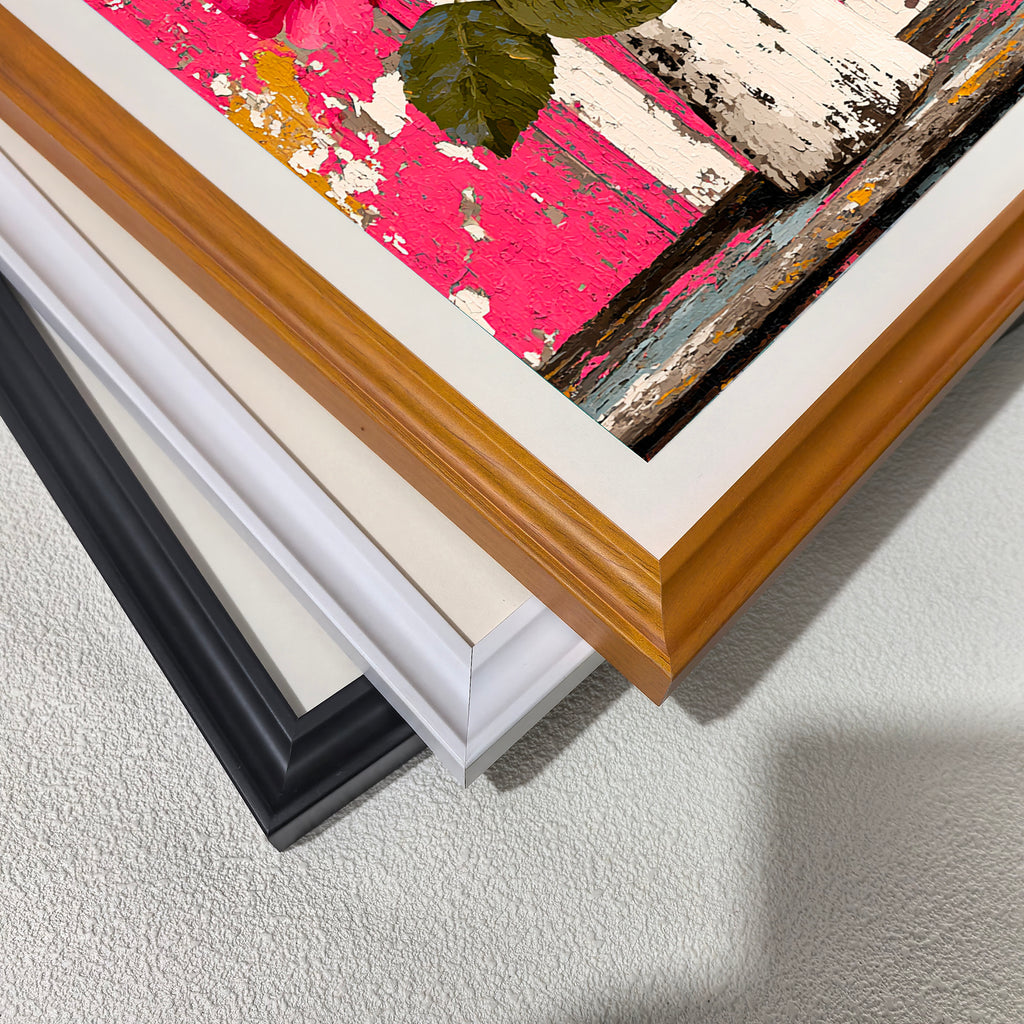 A close-up, stacked view of the corners of three different wooden picture frames: black, white, and light brown (wood grain), placed over a section of the pink rose painting.