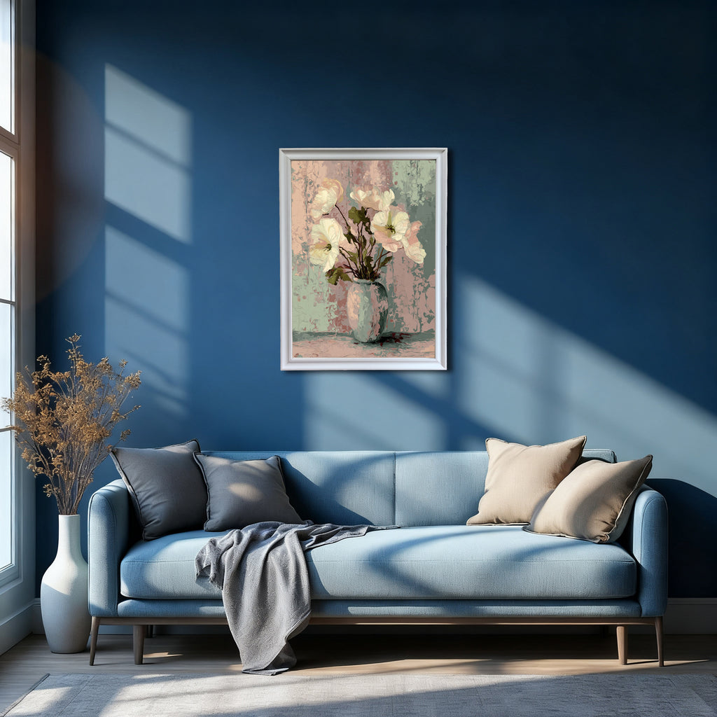 Abstract floral art print in a white frame, featuring white flowers in a pale vase against a textured pastel background, hanging above a light blue sofa on a deep blue wall.