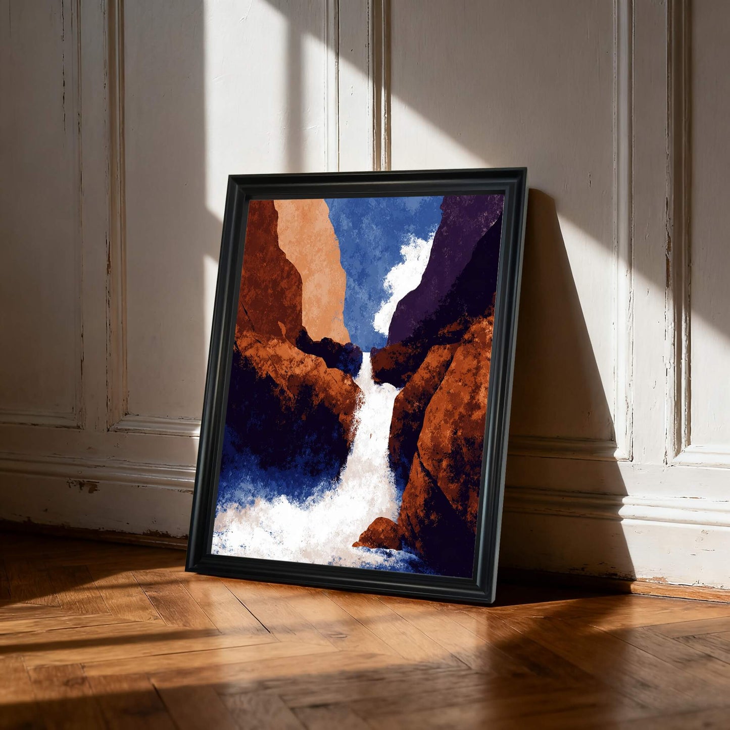 Abstract waterfall print in a black frame, leaning on a wooden floor against a white paneled wall with strong light and shadow.