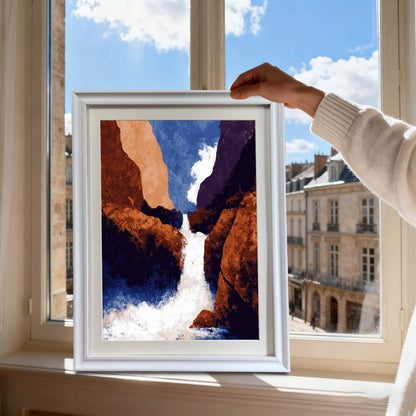 Hands holding the framed abstract waterfall print in a white frame, silhouetted against a bright sunny window overlooking a city street.
