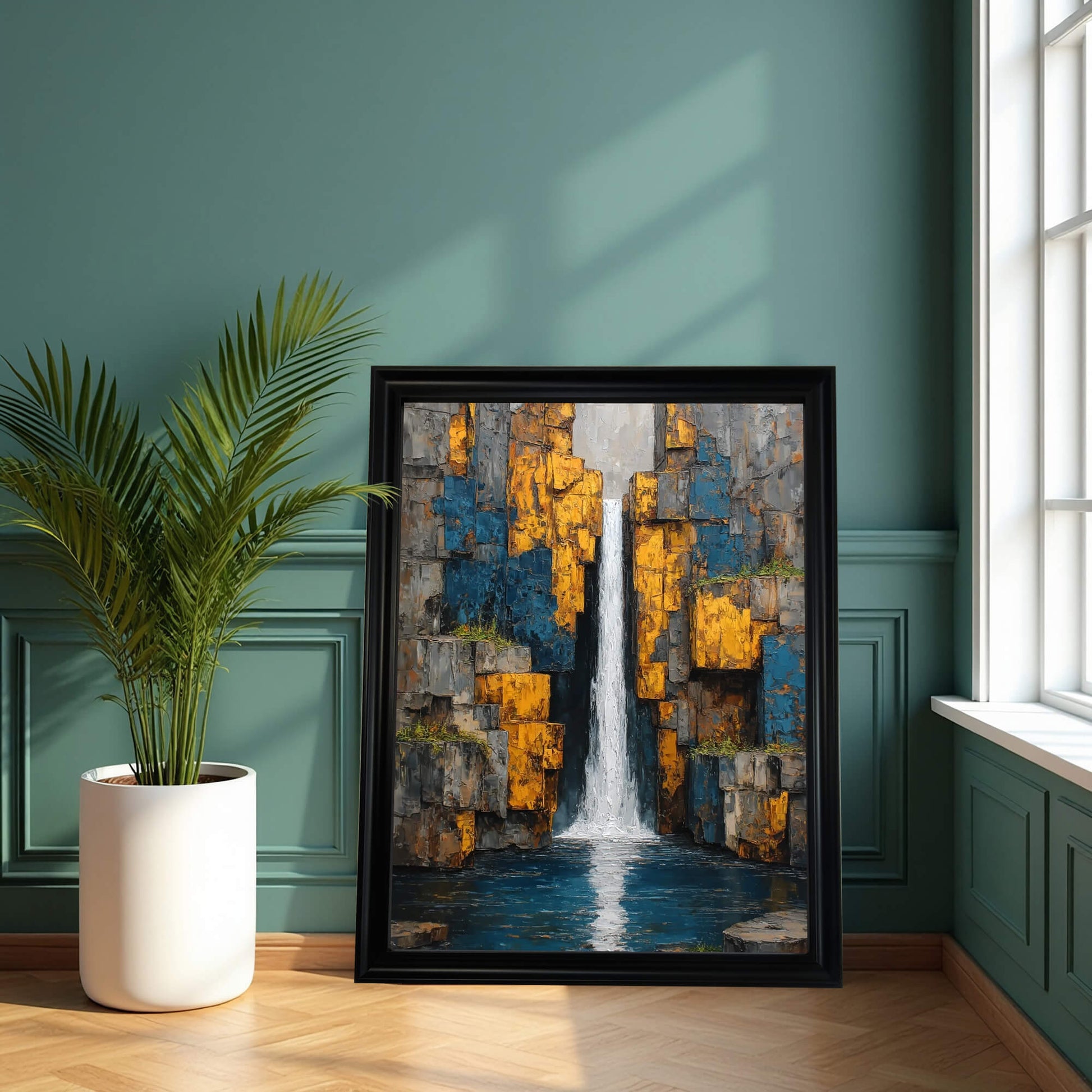 Vertical abstract waterfall art print in a thick black wood frame, leaning on a teal green wall next to a large window and potted palm.