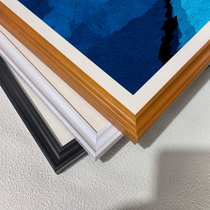 Stacked close-up view of the three different wood frame options: black, white, and dark wood (brown/natural), highlighting the texture of the blue print.
