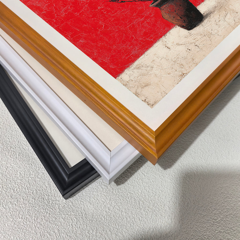 Close-up view of three stacked wood picture frame corners in black, white, and natural brown, showing the art print inside which features striking red and textured white colors.