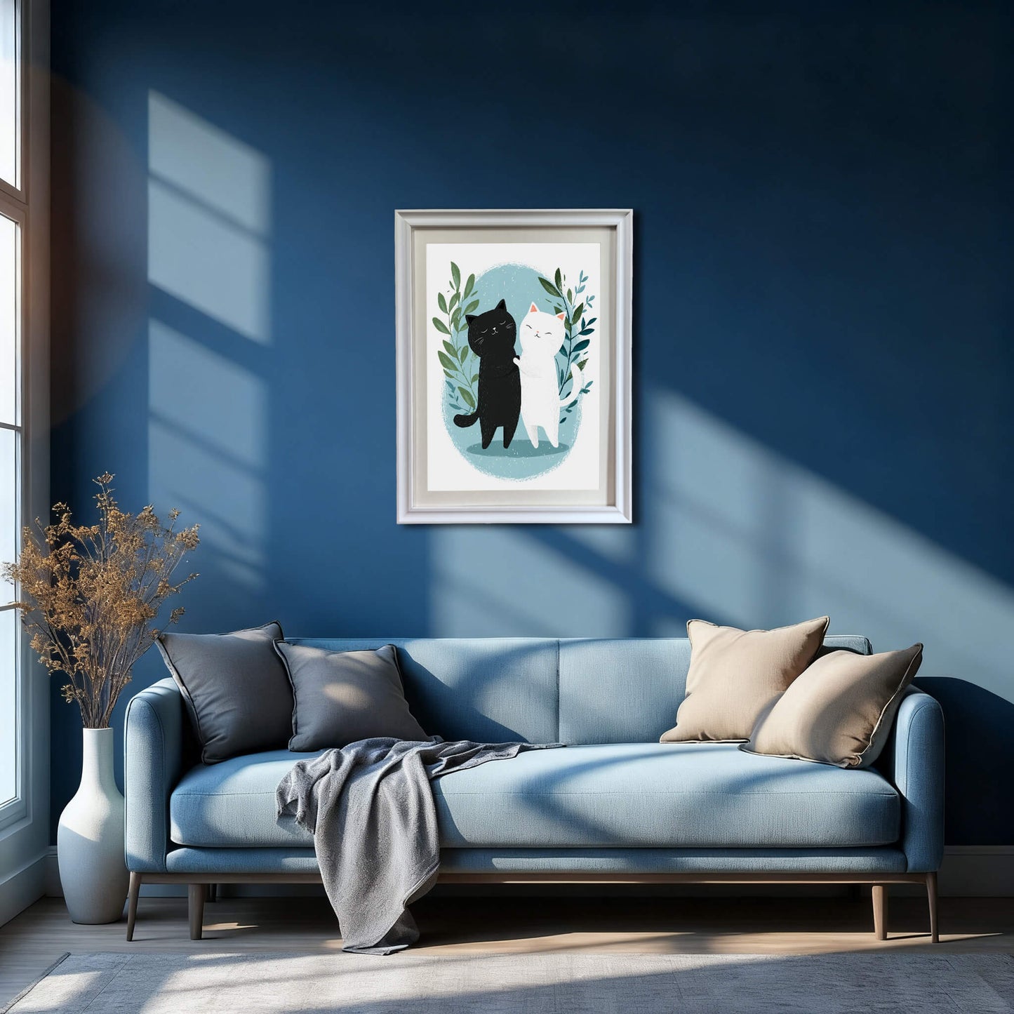 A wide interior shot of a modern living room with deep blue walls. A white-framed print of the hugging cats is centered above a light blue sofa adorned with grey and tan pillows.