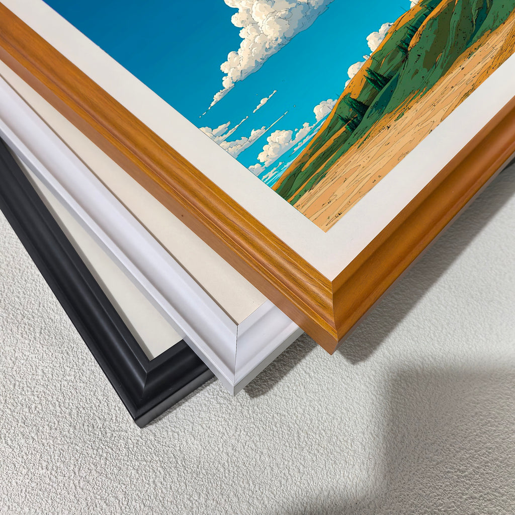 A stack of frame corners: black, off-white, white, and a light wood grain (brown). This displays the different framing options for the blue sky and hillside art print.