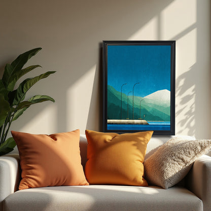 Minimalist geometric art print featuring blue water, teal and green layered mountains, a snow-capped peak, and three streetlights on a pier, in a black frame, hanging above a white sofa with orange pillows.