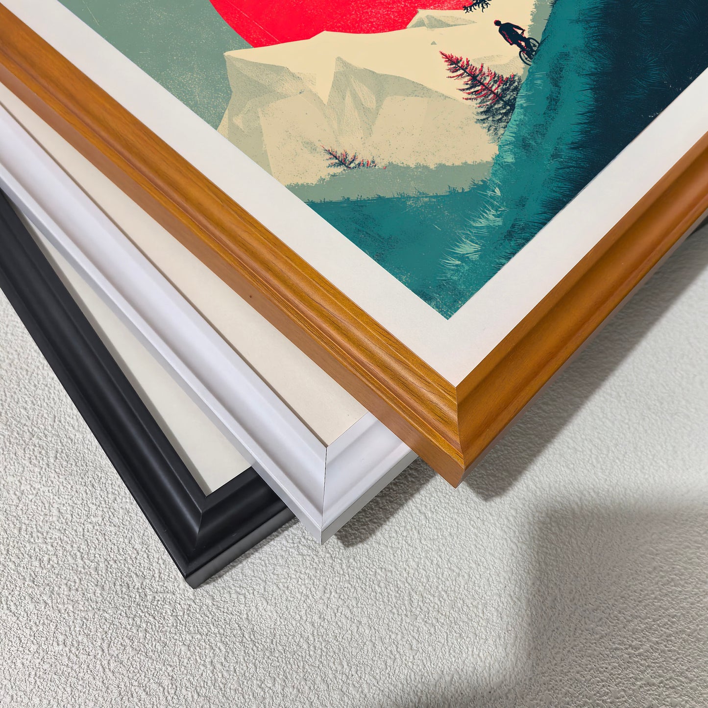 Close-up corner detail of the art print showing three stacked frame options: , white, orange, and black.