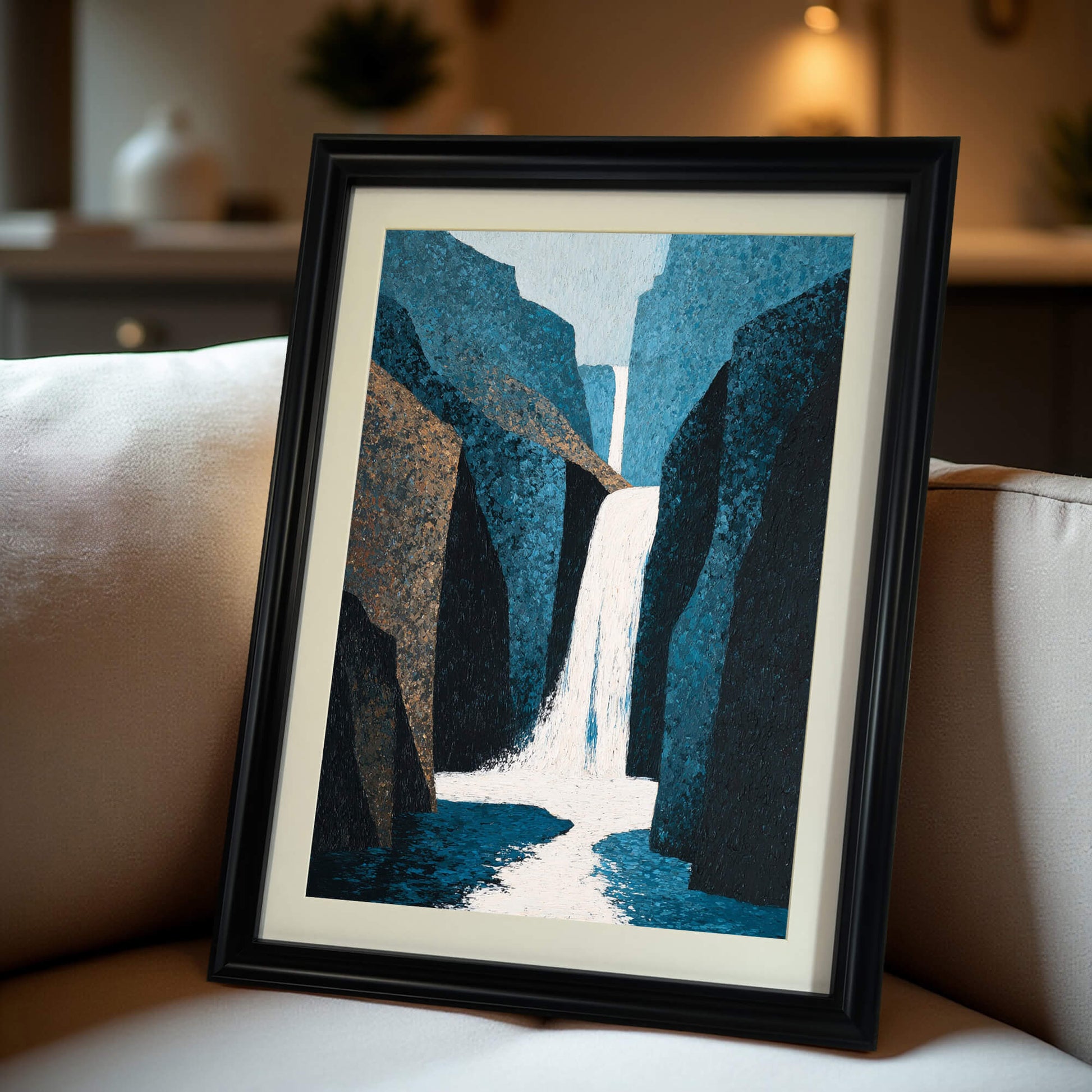 Abstract waterfall art print in a black wood frame with a mat, propped up on a cream-colored couch, offering a close-up view of the framed print in a home setting.