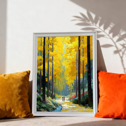 The forest painting in a white frame resting on a floor or low shelf between a yellow velvet pillow and an orange pillow.
