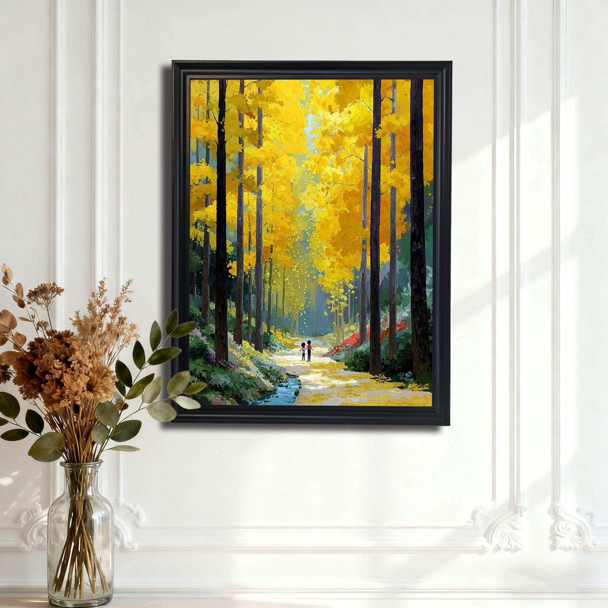 The forest painting in a black frame hanging on a white wall with decorative molding, positioned behind a glass vase of dried flowers.

