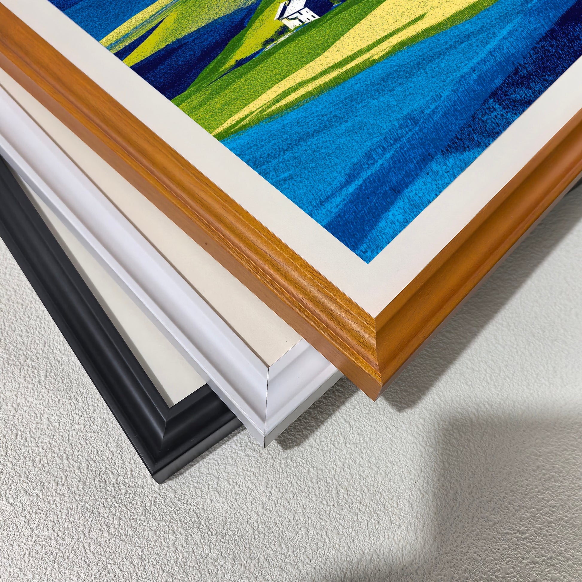 Close-up corner detail of the art print showing three stacked frame options: , white, orange, and black.