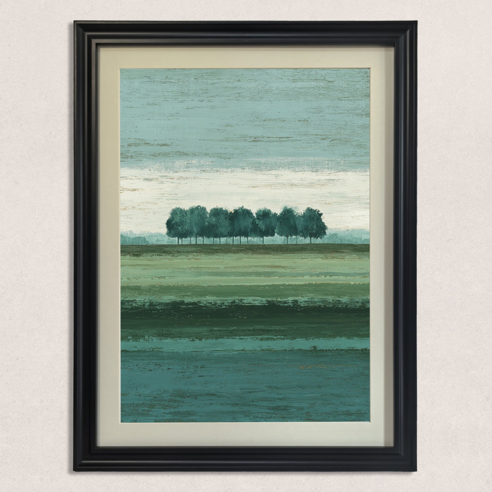 Vertical abstract landscape art print featuring a row of trees and layered shades of green and teal, framed in a classic black wood frame with a cream mat, hanging on a lightly textured beige wall.