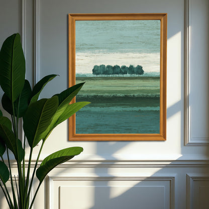 Vertical abstract landscape art print with the row of trees in a natural brown wood frame, hanging on a classic gray wainscoting wall next to a large green houseplant.