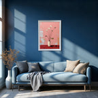 A vertical, white-framed painting of white lotus flowers on a pink and red background hanging above a light blue sofa with beige and gray pillows, in a modern room with dark blue walls and large window shadows.