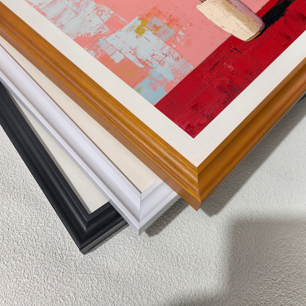 A close-up, stacked view of the corners of three different wooden picture frames: black, white, , and light brown (wood grain), showing the frame profiles and the edge of the painting."