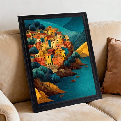 Art print of an Italian town overlooking the water in a black frame, leaning against a beige couch cushion.