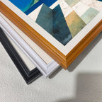 Close-up corner detail of the art print showing three stacked frame options: , white, orange, and black.