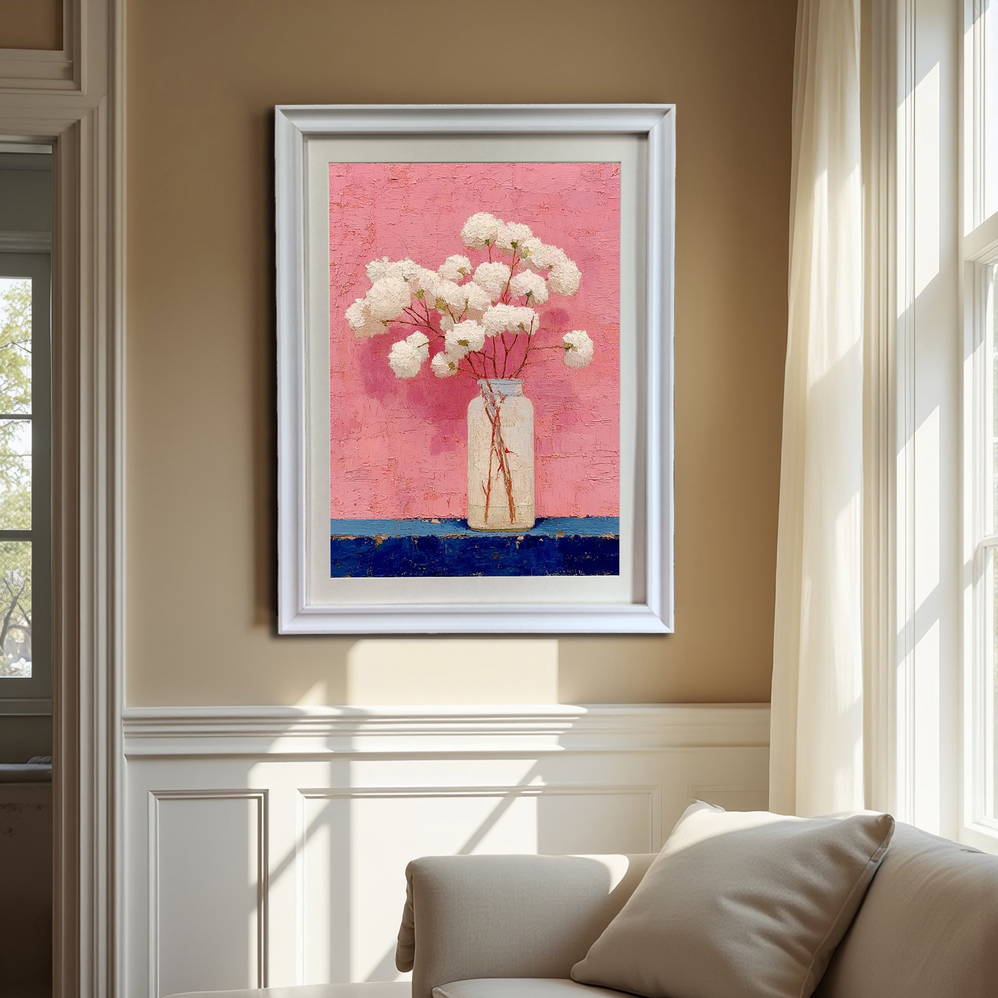 The art print, framed in a classic white frame, is hung above a white couch in a room with light brown walls and large windows with white curtains, demonstrating a bright and elegant display.