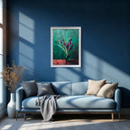 Framed art print of purple flowers in a green vase against a teal background, in a white frame, hanging above a light blue sofa on a deep navy blue wall.