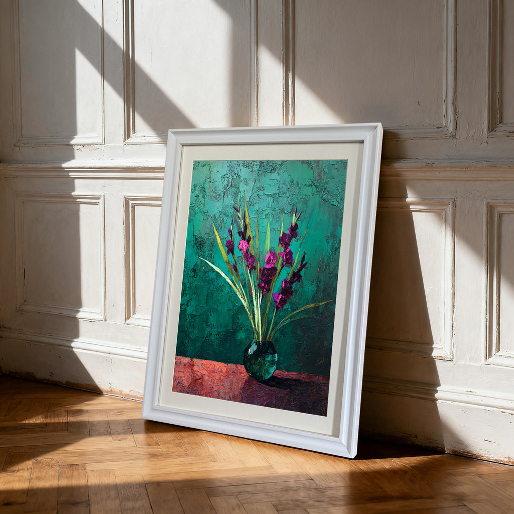 White-framed art print of purple flowers in a vase against a textured teal and red background, leaning on a hardwood floor against a white paneled wall with strong shadows.