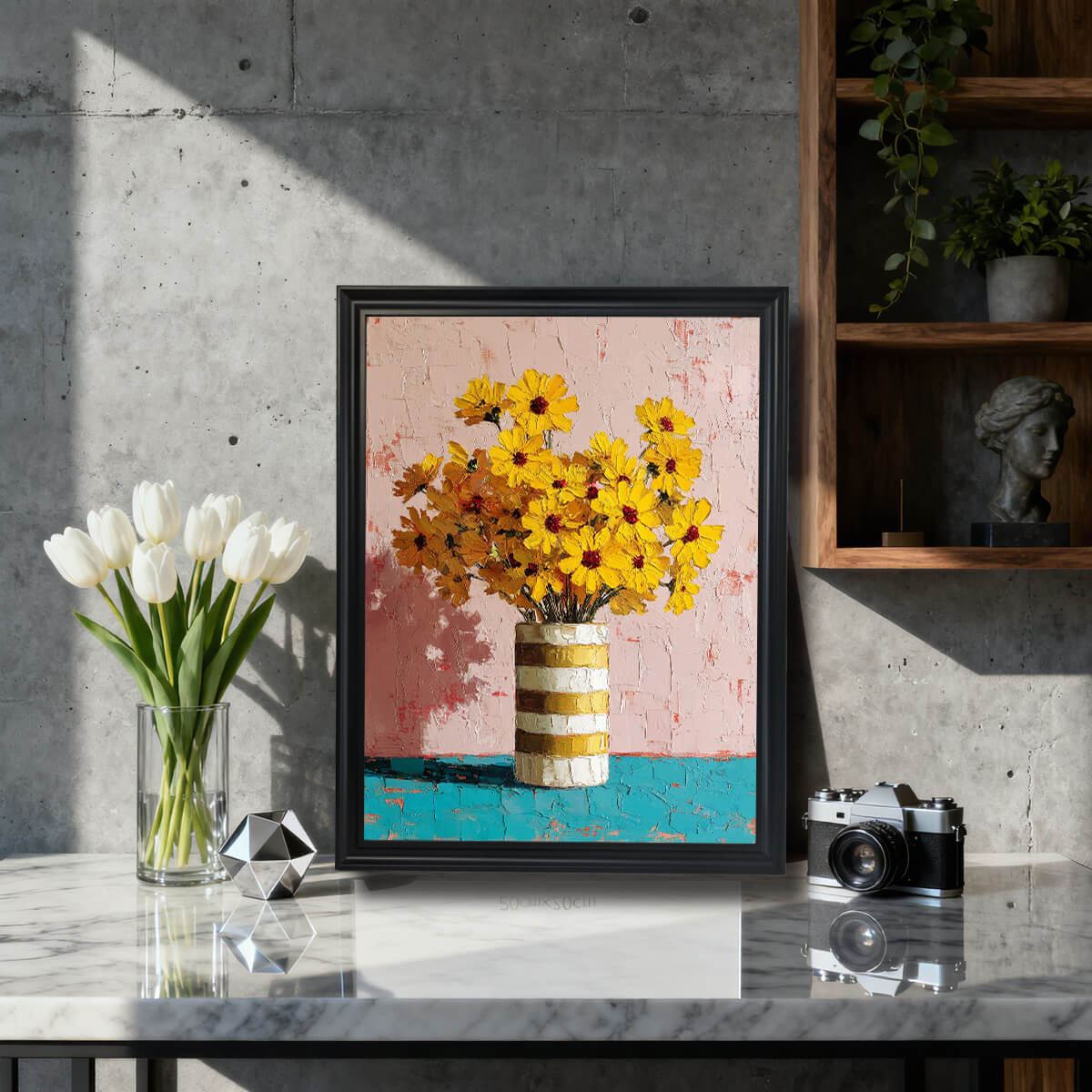 A black-framed impasto oil painting of yellow flowers displayed on a marble countertop in a modern industrial-style room.
