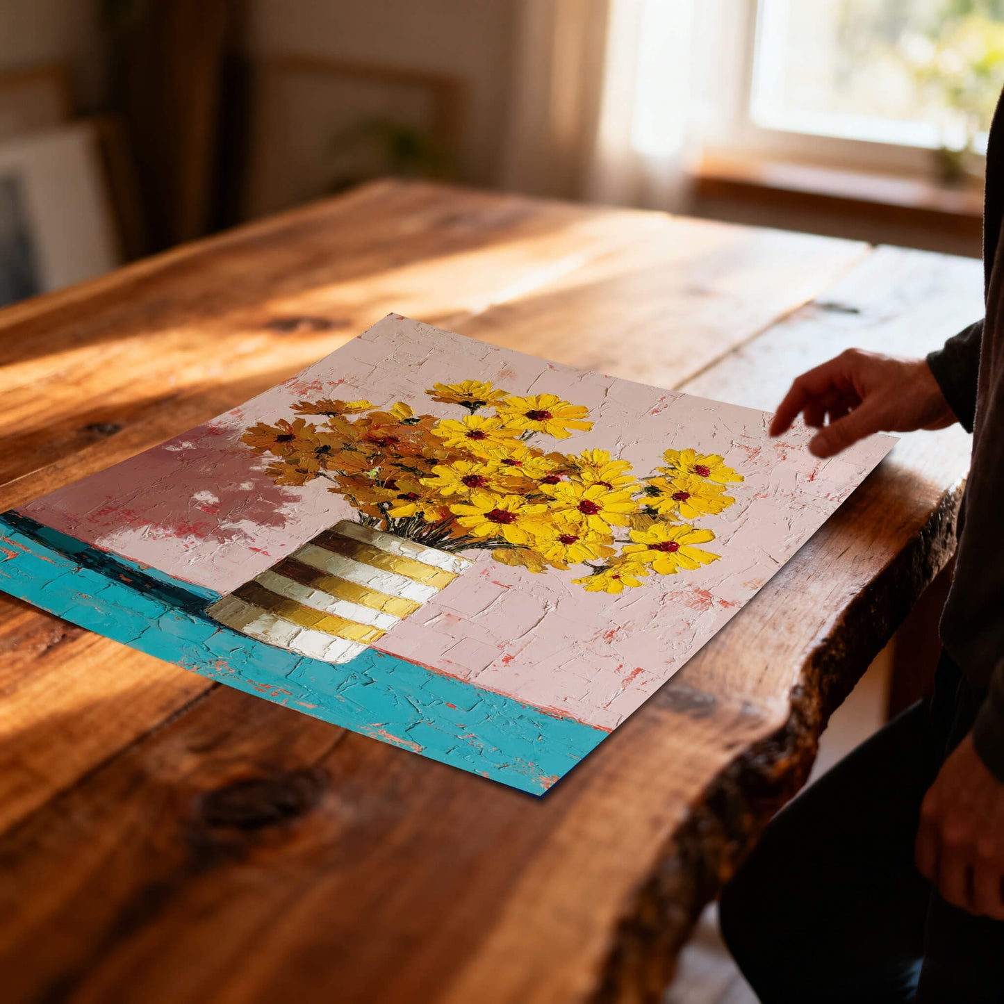 Unframed floral art print resting on a rustic farmhouse wooden table in a sunlit interior.