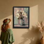 Woman with red curly hair and a green headband looking at a black-framed art print of white and pink flowers in a vase, hanging on a warm beige wall next to a wicker vase with dried grasses.