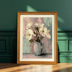 Art print of white flowers in a pale vase, framed in a natural light brown wood frame, leaning on the wooden floor against a dark emerald green paneled wall