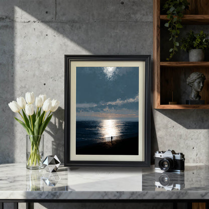 Moody ocean sunset art print in a black wood frame with a mat, sitting on a marble countertop next to white tulips and a vintage camera, styled for modern or industrial decor.