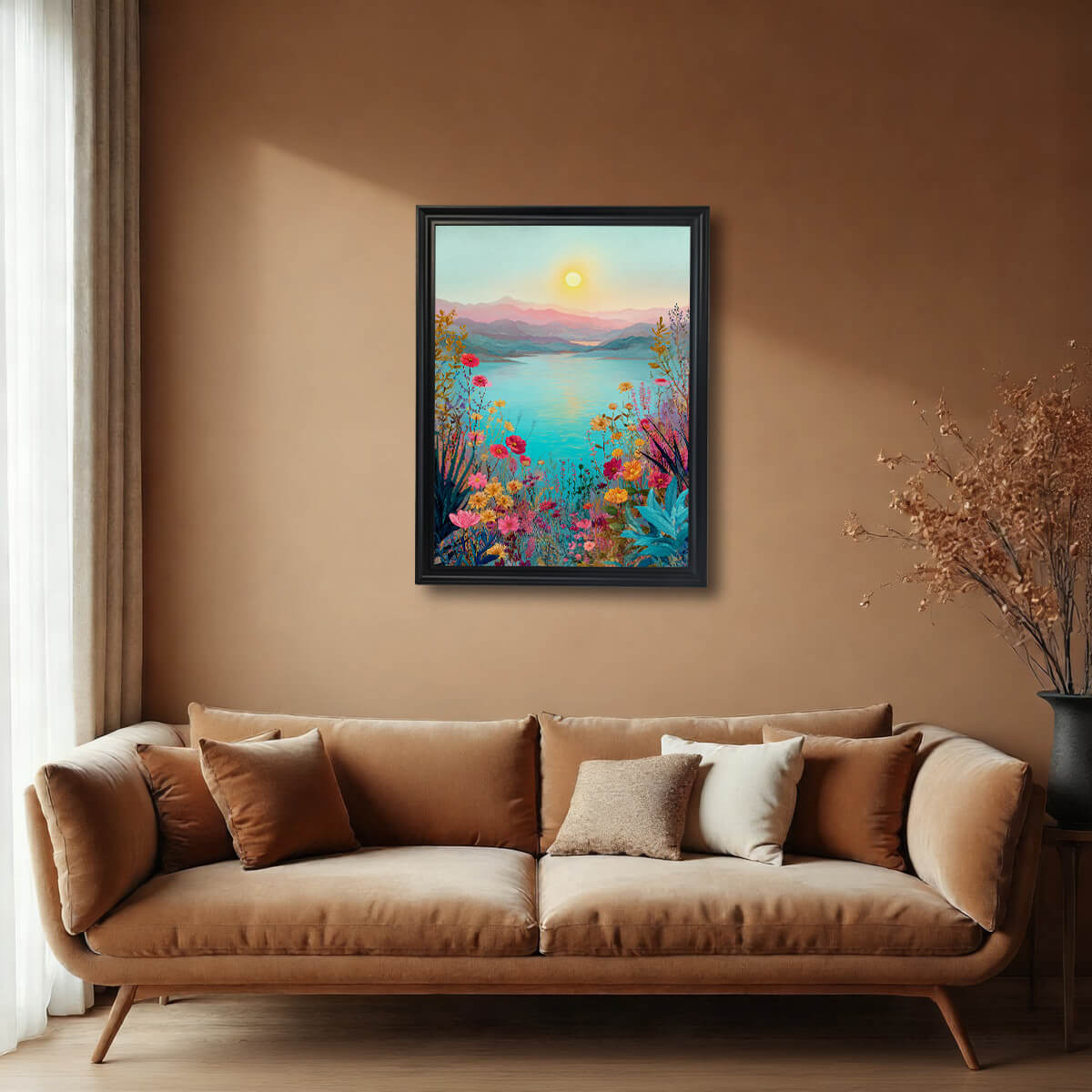 A large, black-framed landscape art print hanging on a warm, beige-colored wall centered above a modern tan velvet sofa with several accent pillows.
