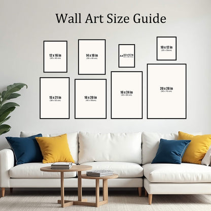 A wall art size guide showing eight different frame dimensions labeled in inches and centimeters, arranged on a wall above a modern white sectional sofa with blue and yellow pillows.