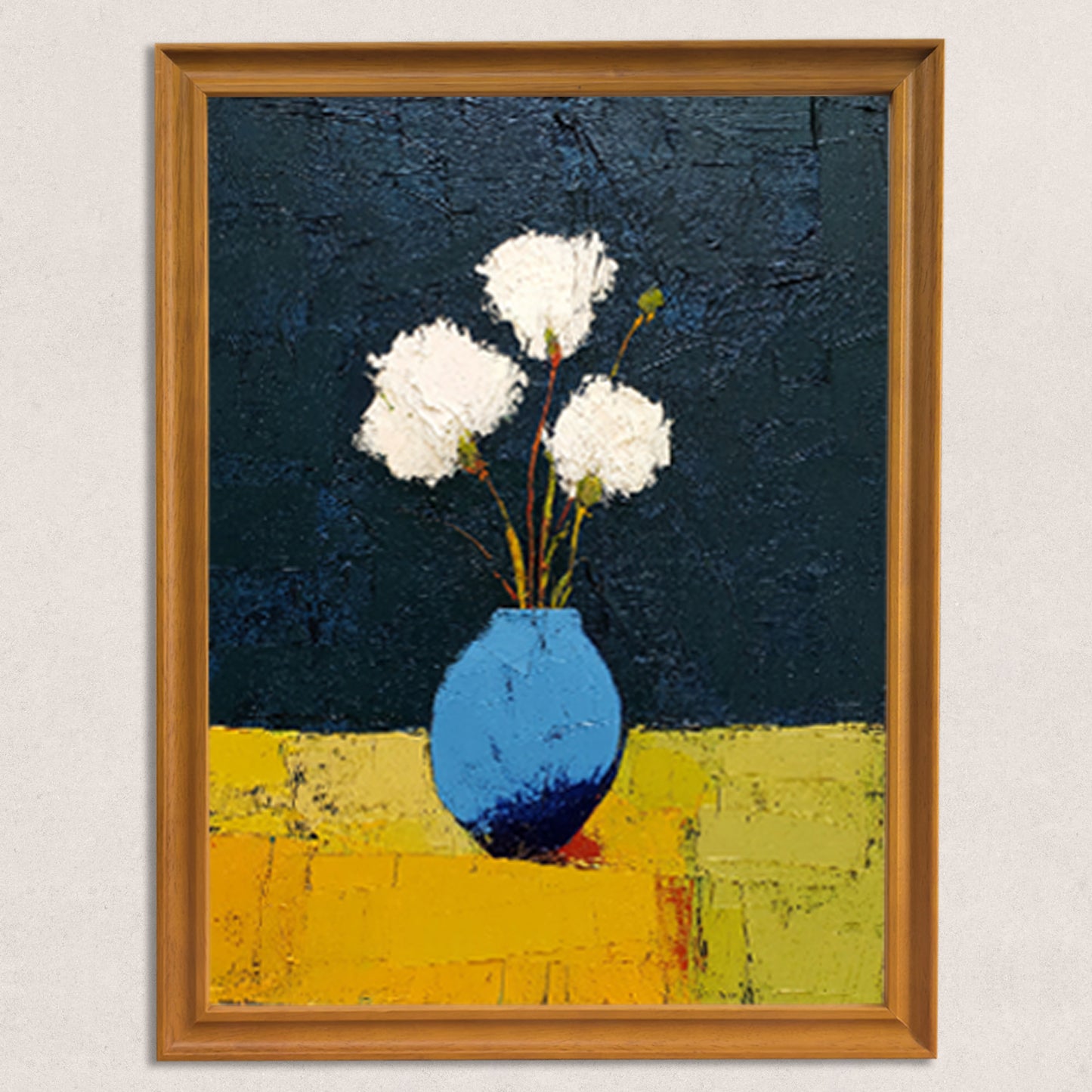 Close-up of the art print itself: abstract painting of three white textured flowers in a blue vase on a yellow surface with a dark blue background, framed in a light brown wood frame.