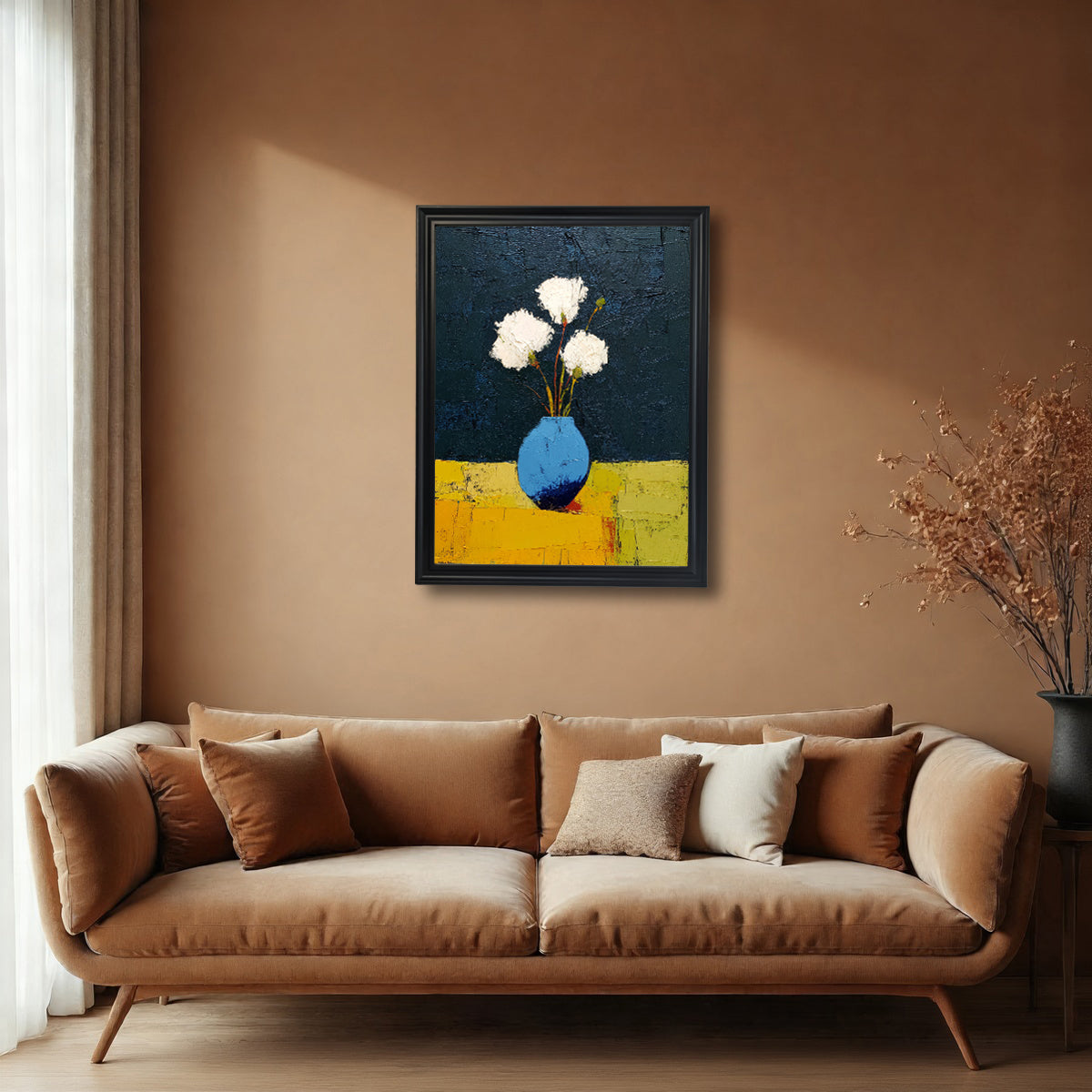 Abstract still life art print of white flowers in a blue vase, hanging on a warm brown wall above a brown velvet sofa with throw pillows, framed in a black wood frame.